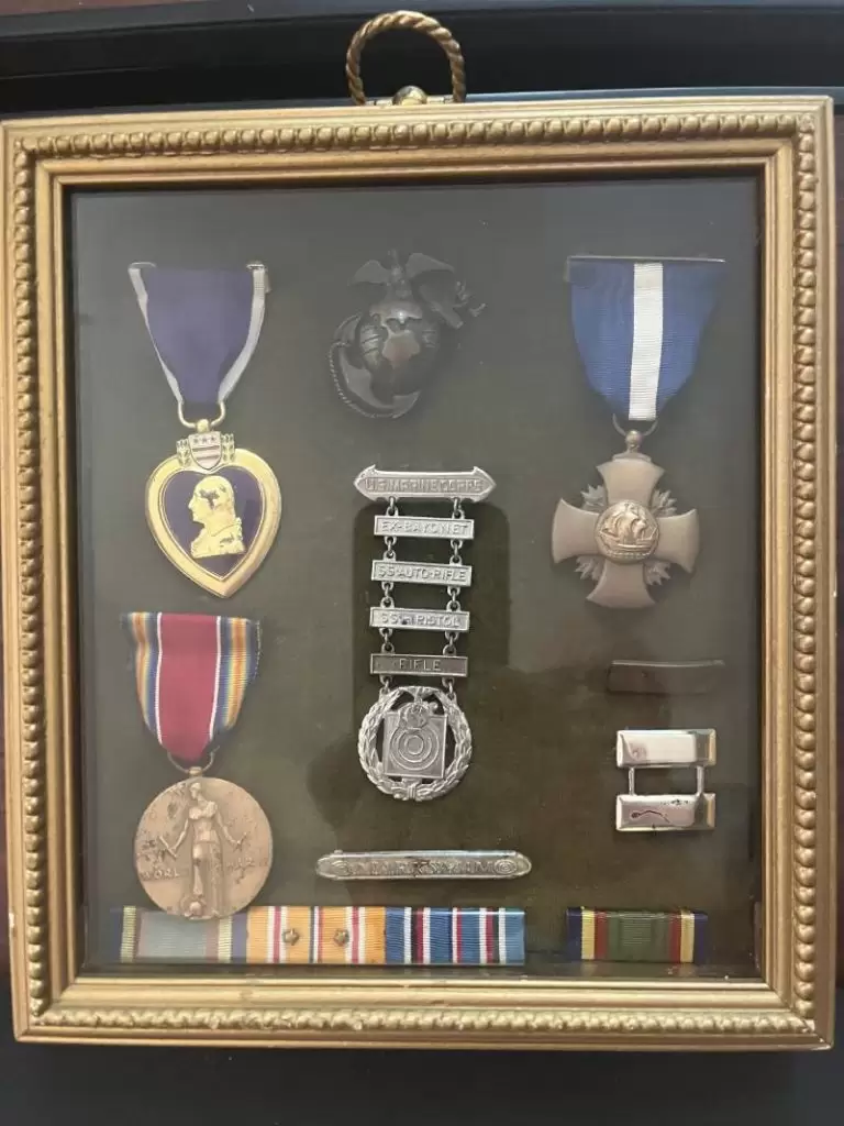 A framed display of Capt. Maurice R. Amundson's military medals, including the Navy Cross (upper right) and Purple Heart (upper left)